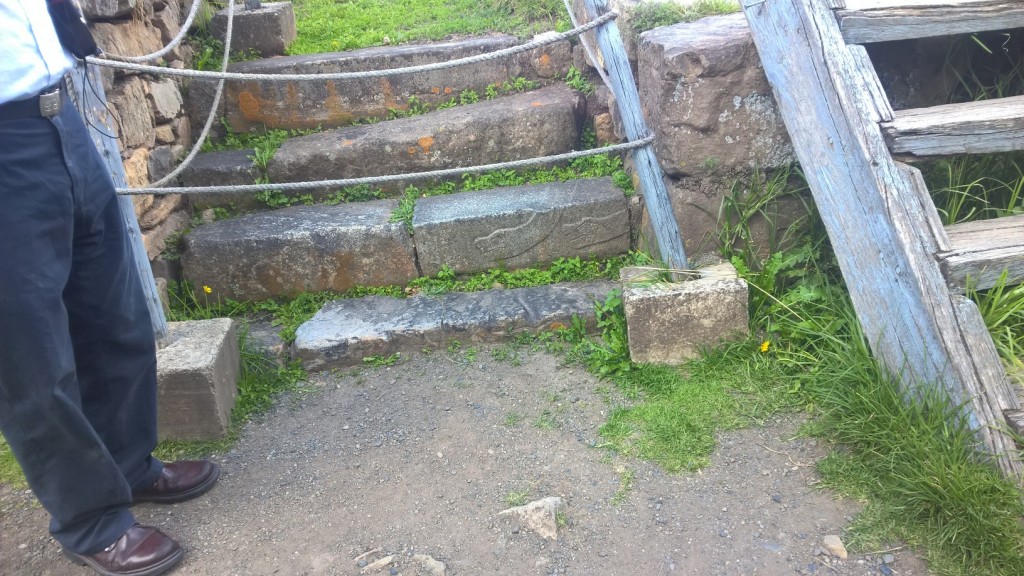 Płaskorzeźba węża na kamiennych schodach